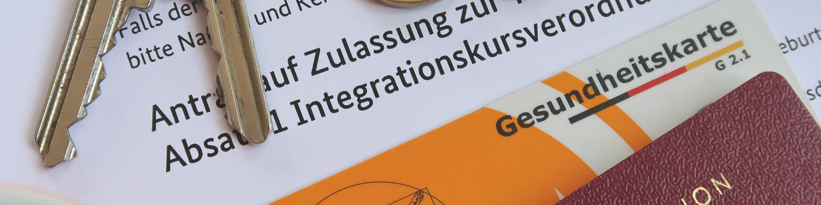 Schlüsselbund, Gesundheitskarte, Ausweisdokument und Antrag auf Integrationskurs – Symbolbild für Alltagshürden von EU-Bürger*innen in Augsburg