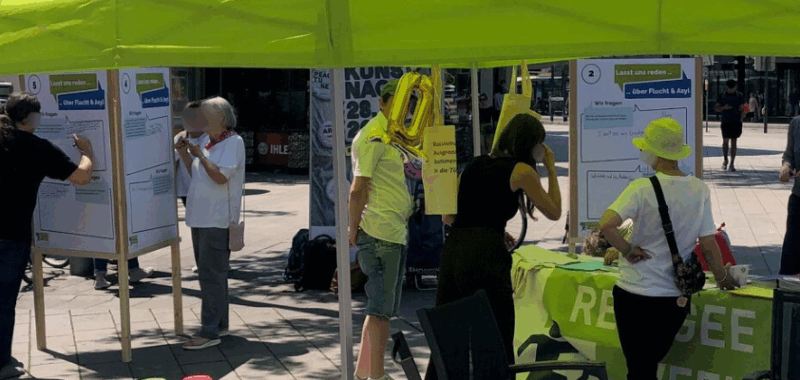 Dialog- und Infostand am Königsplatz in Augsburg zur RefugeeWeek 2025